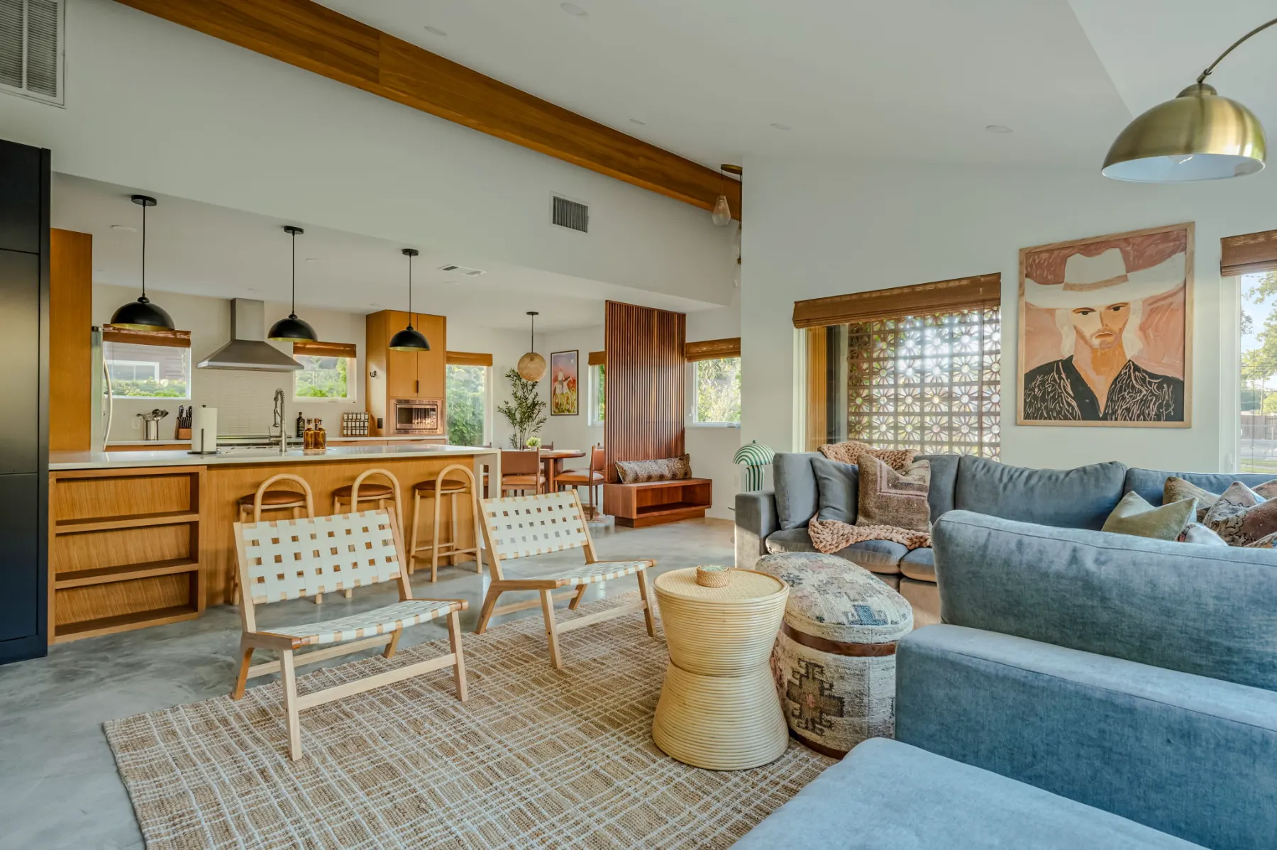 Casa Tranquila: an open kitchen and living room with woven chairs, blue sofas and a cowboy portrait