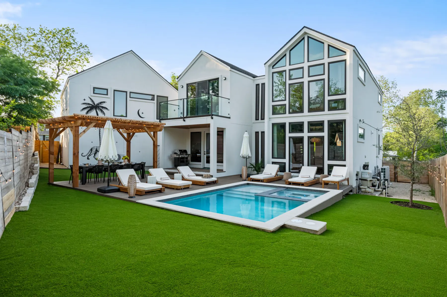 Mount Vernon Estate: a white modern house with tall gabled windows, a pool, loungers and a pergola